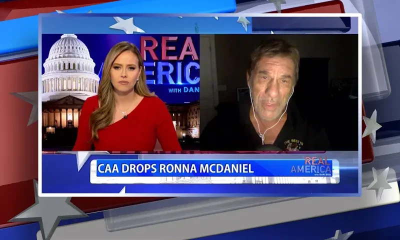 Video still from Real America on One America News Network showing a split screen of the host on the left side, and on the right side is the guest, Robert Davi.