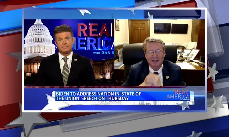 Video still from Real America on One America News Network showing a split screen of the host on the left side, and on the right side is the guest, Rep. Tim Burchett.