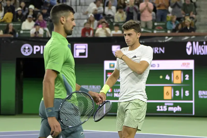 Novak Djokovic (SRB) and Luca Nardi (ITA) pass as they change sides during their third round match in the BNP Paribas Open at the Indian Wells Tennis Garden. Mandatory Credit: Jayne Kamin-Oncea-USA TODAY Sports