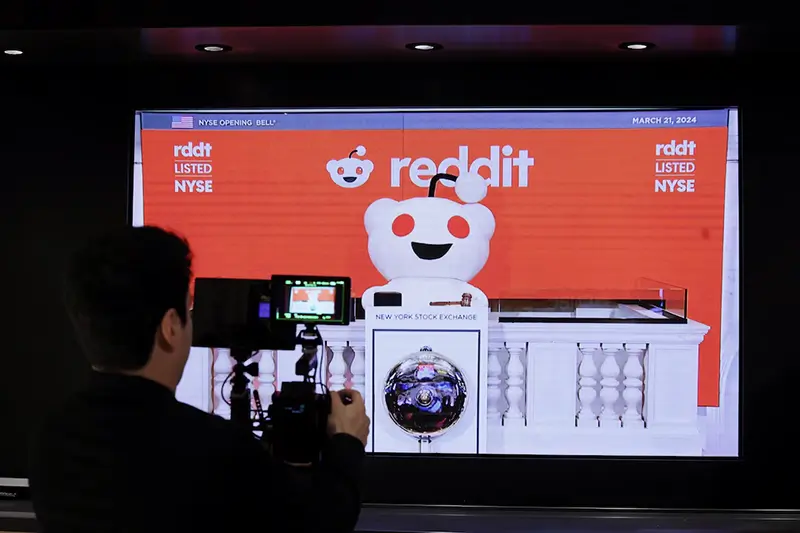 A person records the Reddit mascot as it rings the opening bell, at the New York Stock Exchange (NYSE) in New York City, U.S., March 21, 2024. REUTERS/Brendan McDermid