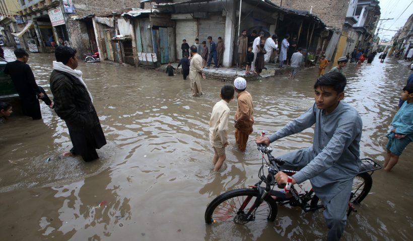 Youngsters wade through a flooded street caused by heavy rain in Peshawar, Pakistan, Monday, April 15, 2024. Lightening and heavy rains killed dozens of people, mostly farmers, across Pakistan in the past three days, officials said Monday, as authorities declared a state of emergency in the country's southwest following an overnight rainfall to avoid any further casualties and damages. (AP Photo/Muhammad Sajjad)