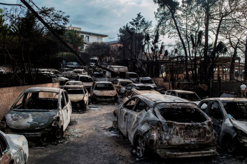TOPSHOT - This photo taken on July 24, 2018 show cars burnt following a wildfire at the village of Mati, near Athens, on July 24, 2018. - Fifty people have died and 170 have been injured in wildfires ravaging woodland and villages in the Athens region, as Greek authorities rush to evacuate residents and tourists stranded on beaches along the coast on July 24, 2018. The death toll soared with a Red Cross official reporting the discovery of 26 bodies in the courtyard of a villa at the seaside resort of Mati. (Photo by ANGELOS TZORTZINIS / AFP) (Photo by ANGELOS TZORTZINIS/AFP via Getty Images)