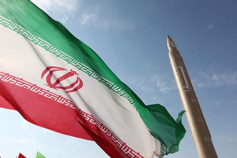 A picture taken on August 20, 2010 shows an Iranian flag fluttering at an undisclosed location in the Islamic republic next to a surface-to-surface Qiam-1 (Rising) missile which was test fired a day before Iran was due to launch its Russian-built first nuclear power plant. Iranian Defence Minister Ahmad Vahidi said the missile was entirely designed and built domestically and powered by liquid fuel. AFP PHOTO/VAHID REZA ALAEI (Photo credit should read VAHID REZA ALAEI/AFP via Getty Images)