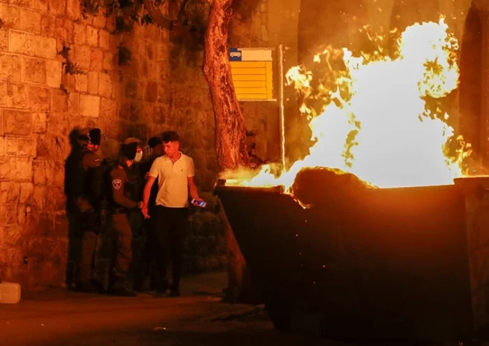 A fire burns in a dumpster as Israeli security forces disperse Palestinian protesters outside the Damascus Gate in Jerusalem's Old City on April 23, 2021, amid mounting tensions over a ban on gatherings and anger fuelled by videos posted of attacks on youths. (Photo by AHMAD GHARABLI / AFP) (Photo by AHMAD GHARABLI/AFP via Getty Images)