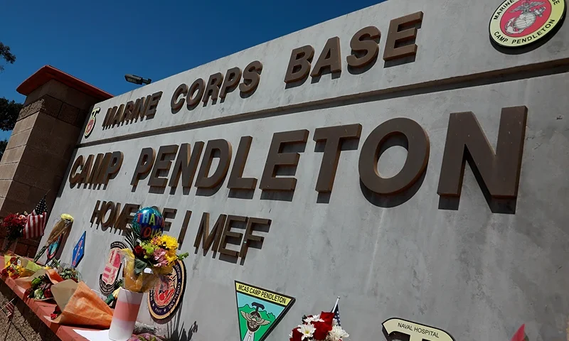 OCEANSIDE, CA - AUGUST 27: Flowers and other keepsakes adorn the entrance sign to Camp Pendleton on August 27, 2021 in Oceanside, California. 170 people were killed, including 13 U.S. Servicemen during an ISIS-led terrorist attack outside of the Kabul Airport. (Photo by Sandy Huffaker/Getty Images)