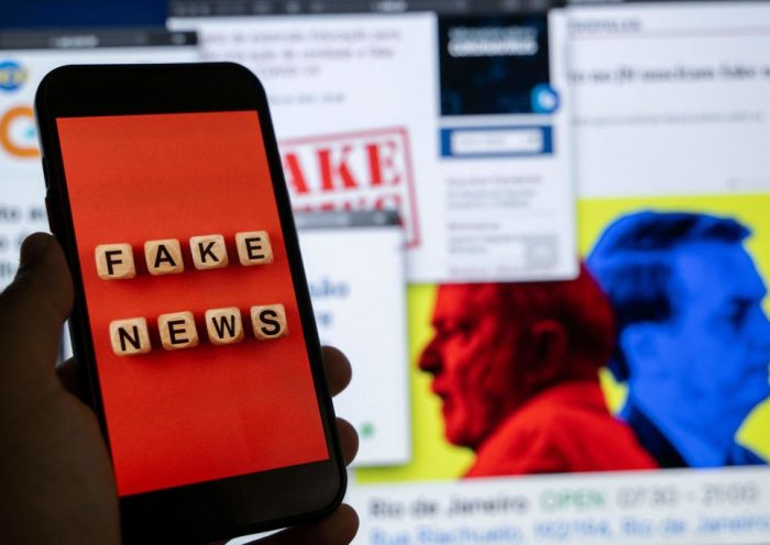 This illustration picture shows a smart phone screen displaying the phrase "Fake News" in front of a desktop screen showing several news and research reports about fake news and disinformation related to the upcoming Brazilian presidential election, in Rio de Janeiro, Brazil, on August 29, 2022. - The sheer volume of fake news, creation of new social media platforms and ever more complex content has made it even more difficult to verify information ahead of the October 2 presidential elections. (Photo by Mauro PIMENTEL / AFP) (Photo by MAURO PIMENTEL/AFP via Getty Images)