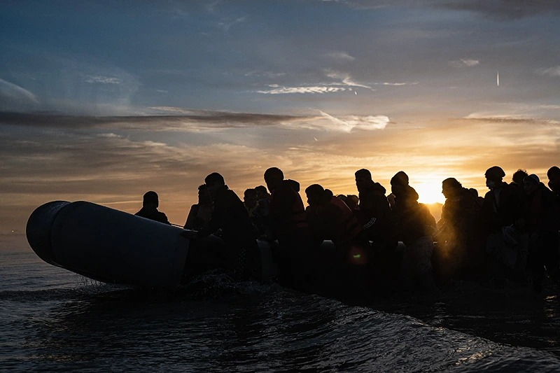 TOPSHOT - Migrants board a smuggler's boat on the beach of Gravelines, near Dunkirk, northern France on October 12, 2022, in a attempt to cross the English Channel. (Photo by Sameer Al-DOUMY / AFP) (Photo by SAMEER AL-DOUMY/AFP via Getty Images)