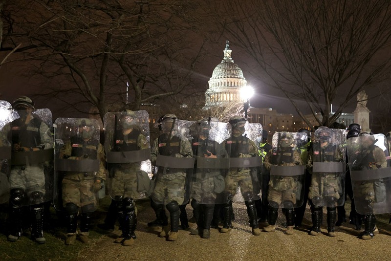 WASHINGTON, DC - JANUARY 06: Members of the National Guard assist police officers line up as they assist police in dispersing protesters who are gathering at the U.S. Capitol Building on January 06, 2021 in Washington, DC. Pro-Trump protesters entered the U.S. Capitol building after mass demonstrations in the nation's capital during a joint session Congress to ratify President-elect Joe Biden's 306-232 Electoral College win over President Donald Trump. (Photo by Tasos Katopodis/Getty Images)