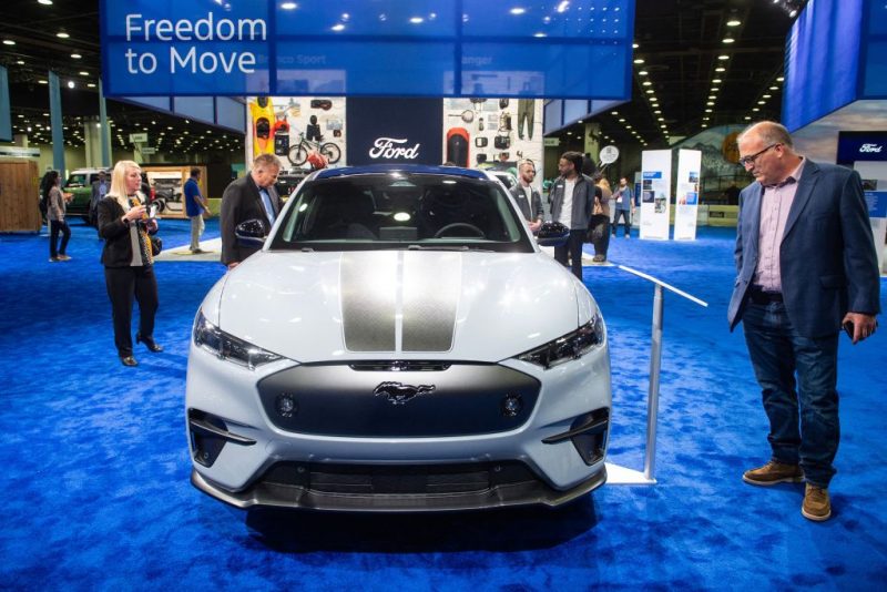 Attendees admire the 2024 Ford Mustang Mach-E Rally during the North American International Auto Show at the Huntington Place convention center in Detroit, Michigan, on September 14, 2023. (Photo by Matthew Hatcher / AFP) (Photo by MATTHEW HATCHER/AFP via Getty Images)