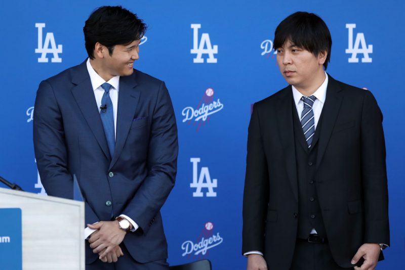 LOS ANGELES, CALIFORNIA - DECEMBER 14: Shohei Ohtani speaks with his interpreter Ippei Mizuhara prior to being introduced by the Los Angeles Dodgers at Dodger Stadium on December 14, 2023 in Los Angeles, California. (Photo by Meg Oliphant/Getty Images)