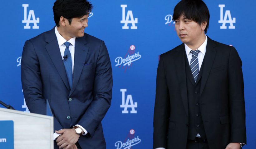 LOS ANGELES, CALIFORNIA - DECEMBER 14: Shohei Ohtani speaks with his interpreter Ippei Mizuhara prior to being introduced by the Los Angeles Dodgers at Dodger Stadium on December 14, 2023 in Los Angeles, California. (Photo by Meg Oliphant/Getty Images)
