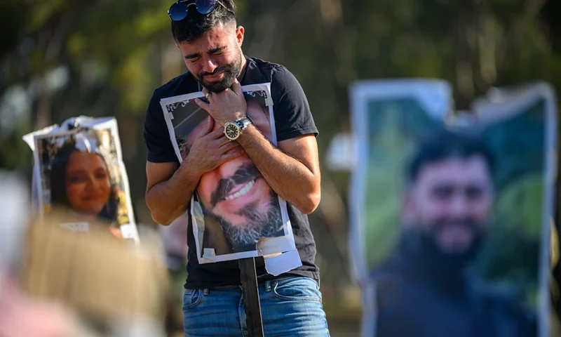 Visitors Pay Respects To Victims Of Oct. 7 Attacks At Nova Festival Site RE'IM, ISRAEL - DECEMBER 18: Rudy Glazer, whose brother Ranani Glazer (aged 23) was killed on the Oct 7 attack, hugs a photo of his brother at a photo memorial at the site of the Super Nova music festival on December 18, 2023 at the Nova festival site in Re'im, Israel. The music festival was among the first sites attacked by Hamas militants on Oct. 7, sparking the current war between Israel and Hamas. (Photo by Alexi J. Rosenfeld/Getty Images)