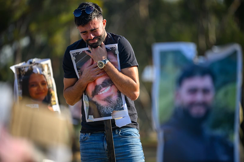 Visitors Pay Respects To Victims Of Oct. 7 Attacks At Nova Festival Site
RE'IM, ISRAEL - DECEMBER 18: Rudy Glazer, whose brother Ranani Glazer (aged 23) was killed on the Oct 7 attack, hugs a photo of his brother at a photo memorial at the site of the Super Nova music festival on December 18, 2023 at the Nova festival site in Re'im, Israel. The music festival was among the first sites attacked by Hamas militants on Oct. 7, sparking the current war between Israel and Hamas. (Photo by Alexi J. Rosenfeld/Getty Images)