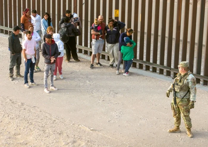 EL PASO, TEXAS - MARCH 13: In an aerial view, a Texas National Guard soldier watches over immigrants after they crossed the U.S.-Mexico border to request asylum on March 13, 2024 in El Paso, Texas. The border between the two nations stretches nearly 2,000 miles, from the Gulf of Mexico to the Pacific Ocean and is marked by fences, deserts, mountains and the Rio Grande, which runs the entire length of Texas. The politics and controversies surrounding border and immigration issues have become dominant themes in the U.S. presidential election campaign. (Photo by John Moore/Getty Images)