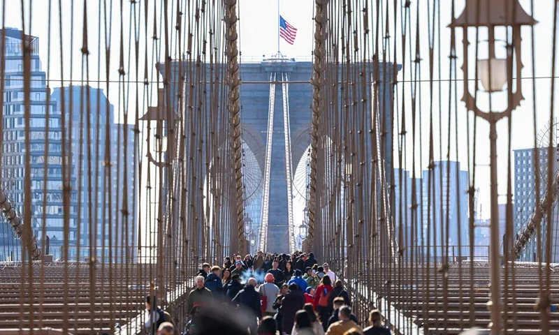 Tourists walk across the Brooklyn Bridge in New York on March 29, 2024. (Photo by Charly TRIBALLEAU / AFP) (Photo by CHARLY TRIBALLEAU/AFP via Getty Images)