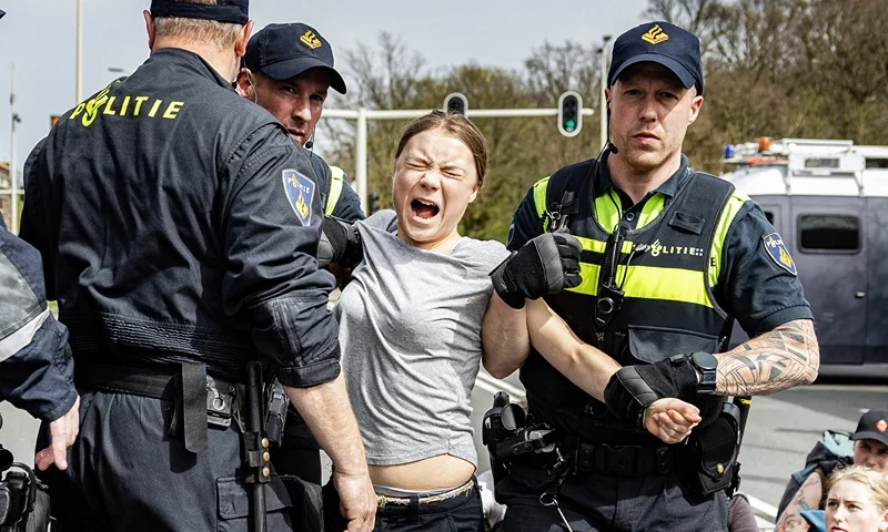 NETHERLANDS-ENVIRONMENT-CLIMATE-DEMO Swedish climate activist Greta Thunberg (C) is arrested during a climate march against fossil subsidies near the highway A12 in the Hague, on April 6, 2024. Dozens of police officers, some on horseback, blocked protesters from reaching the A12 arterial highway into the Dutch seaside city, the scene of previous actions organised by the Extinction Rebellion (XR) group (Photo by Ramon van Flymen / ANP / AFP) / Netherlands OUT (Photo by RAMON VAN FLYMEN/ANP/AFP via Getty Images)