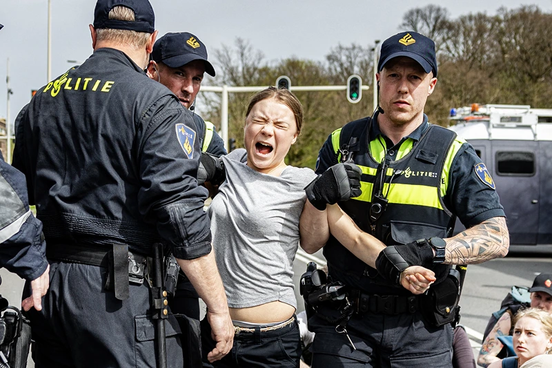 NEDERLAND-ENVIRONMENT-CLIMATE-DEMO
De Zweedse klimaatactiviste Greta Thunberg (C) wordt gearresteerd tijdens een klimaatmars tegen fossiele subsidies bij de snelweg A12 in Den Haag, op 6 april 2024. Tientallen politieagenten, sommigen te paard, blokkeerden demonstranten bij het bereiken van de verkeersader A12 naar de Nederlandse kuststad, het toneel van eerdere acties georganiseerd door de Extinction Rebellion (XR) groep (Foto door Ramon van Flymen / ANP / AFP) / Nederland UIT (Foto door RAMON VAN FLYMEN/ANP/AFP via Getty Images)
