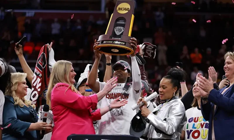CLEVELAND, OHIO - APRIL 07: Sania Feagin #20 of the South Carolina Gamecocks hoists the trophy after beating the Iowa Hawkeyes in the 2024 NCAA Women's Basketball Tournament National Championship at Rocket Mortgage FieldHouse on April 07, 2024 in Cleveland, Ohio. South Carolina beat Iowa 87-75 (Photo by Gregory Shamus/Getty Images)