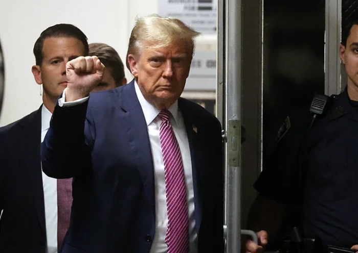 Former US President Donald Trump gestures as he enters Manhattan Criminal Court after a lunch break during his trial for allegedly covering up hush money payments linked to extramarital affairs, in New York City on April 19, 2024. A panel of 12 jurors was sworn in on April 18, 2024, for the unprecedented criminal trial of a former US president. (Photo by Spencer Platt / POOL / AFP) (Photo by SPENCER PLATT/POOL/AFP via Getty Images)