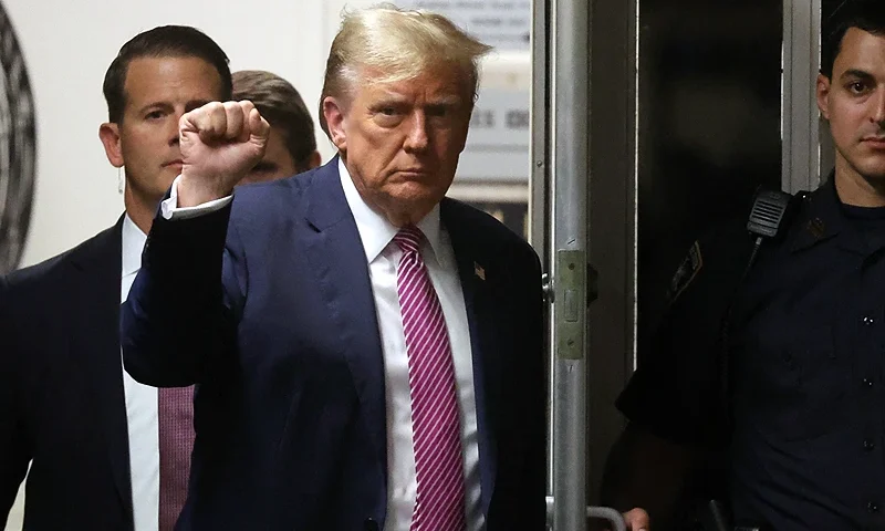 Former US President Donald Trump gestures as he enters Manhattan Criminal Court after a lunch break during his trial for allegedly covering up hush money payments linked to extramarital affairs, in New York City on April 19, 2024. A panel of 12 jurors was sworn in on April 18, 2024, for the unprecedented criminal trial of a former US president. (Photo by Spencer Platt / POOL / AFP) (Photo by SPENCER PLATT/POOL/AFP via Getty Images)