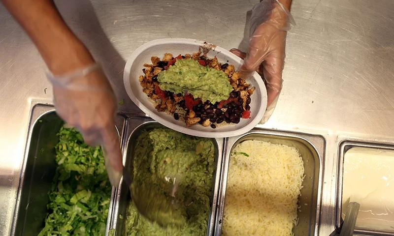 Chipotle Becomes First Non-GMO US Restaurant Chain MIAMI, FL - APRIL 27: Chipotle restaurant workers fill orders for customers on the day that the company announced it will only use non-GMO ingredients in its food on April 27, 2015 in Miami, Florida. The company announced, that the Denver-based chain would not use the GMO's, which is an organism whose genome has been altered via genetic engineering in the food served at Chipotle Mexican Grills. (Photo by Joe Raedle/Getty Images)