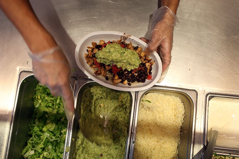 Chipotle Becomes First Non-GMO US Restaurant Chain
MIAMI, FL - APRIL 27: Chipotle restaurant workers fill orders for customers on the day that the company announced it will only use non-GMO ingredients in its food on April 27, 2015 in Miami, Florida. The company announced, that the Denver-based chain would not use the GMO's, which is an organism whose genome has been altered via genetic engineering in the food served at Chipotle Mexican Grills. (Photo by Joe Raedle/Getty Images)