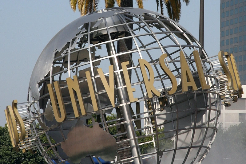 The entrance of Universal Studios in Hollywood, UNITED STATES: The entrance of Universal Studios in Hollywood is pictured 09 April 2007. Universal Studios Hollywood is the original Universal Studios theme park, created initially to offer tours of the real Universal Studios soundstages and sets. It is one of four fully-fledged Universal Studios Theme Parks, along with Universal Studios Orlando, Universal Studios Japan, and the upcoming Universal Studios Singapore, which will be completed by 2010. From the beginning, Universal has offered tours of its studio. In the silent-film days, Carl Laemmle's tour included a chance to buy fresh produce, since then-rural Universal City was still in part a working farm. Shortly after MCA took over Universal Pictures in 1962, accountants suggested a tour stop in the studio commissary would increase profits, and in 1964, the modest tour was expanded to include a series of dressing room walk-throughs, peeks at actual production, and later, staged events. This grew over the years into a full-blown theme park - the narrated tram (formerly "Glamortram") tour still runs through the studio's active backlot, but the staged events, stunt demonstrations and high-tech rides overshadow the motion-picture production that once lured fans in Universal Studios Hollywood. AFP PHOTO/GABRIEL BOUYS (Photo credit should read GABRIEL BOUYS/AFP via Getty Images)