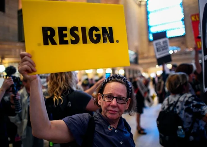 A protester displays a placard calling on US President Donald Trump to resign during Rise and Resist Against White Supremacy demonstration inside the Grand Central Station in New York on September 18, 2017. US President Donald Trump will deliver his maiden address on Day One of the 72nd session of United Nations General Assembly on September 19, 2017. / AFP PHOTO / Jewel SAMAD (Photo credit should read JEWEL SAMAD/AFP via Getty Images)