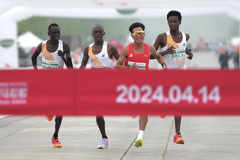 Chinese runner He Jie, Ethiopian Dejene Hailu Bikila and Kenyans Robert Keter and Willy Mnangat take part in a half-marathon in Beijing, China April 14, 2024. cnsphoto via REUTERS/File Photo