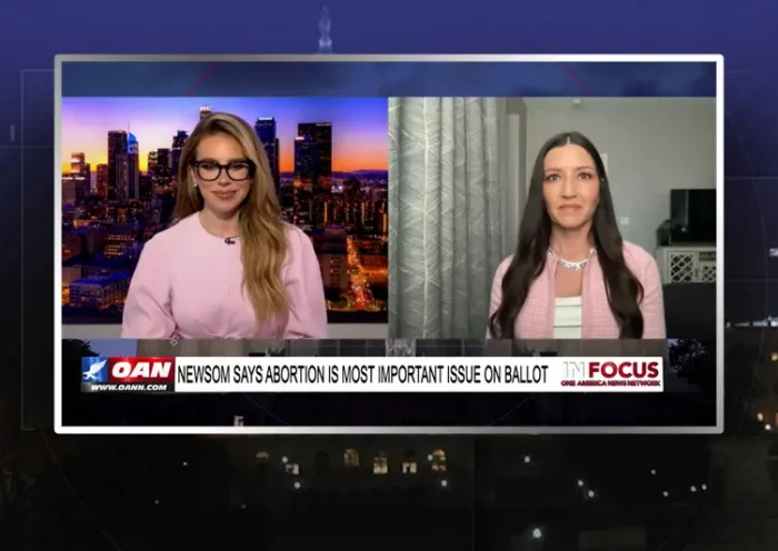 Video still from In Focus on One America News Network showing a split screen of the host on the left side, and on the right side is the guest, Sonja Shaw.