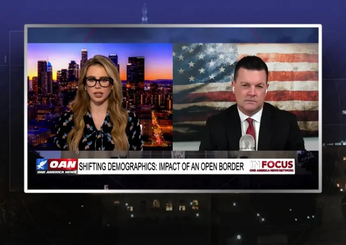 Video still from In Focus on One America News Network showing a split screen of the host on the left side, and on the right side is the guest, J.J. Carrell.