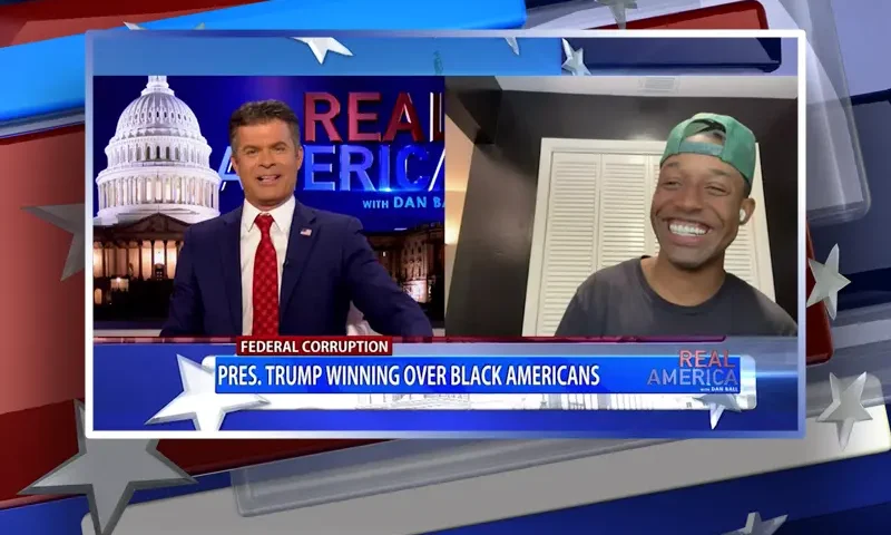 Video still from Real America on One America News Network showing a split screen of the host on the left side, and on the right side is the guest, Joel Patrick.
