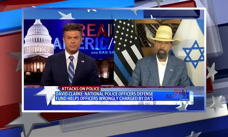 Video still from Real America on One America News Network showing a split screen of the host on the left side, and on the right side is the guest, Sheriff David Clarke.