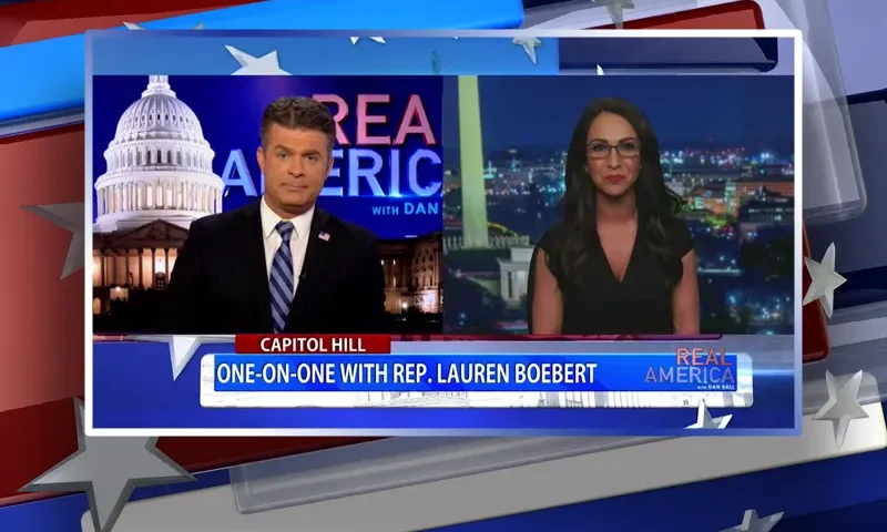 Video still from Real America on One America News Network showing a split screen of the host on the left side, and on the right side is the guest, Rep. Lauren Boebert.
