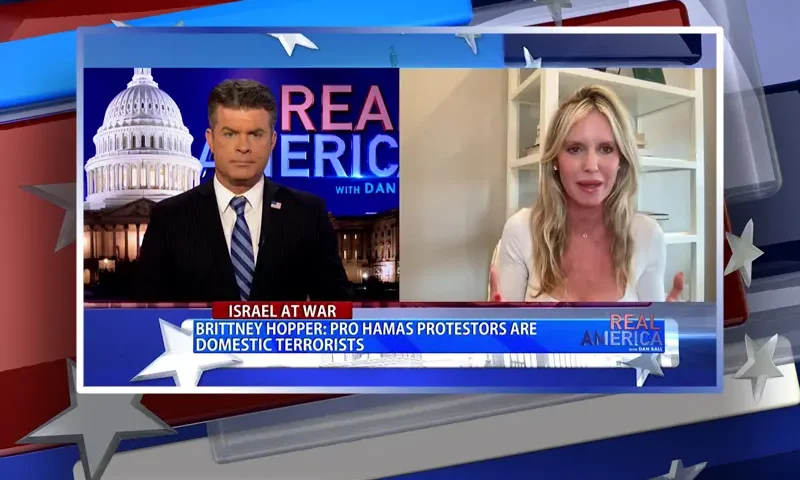 Video still from Real America on One America News Network showing a split screen of the host on the left side, and on the right side is the guest, Brittney Hopper.