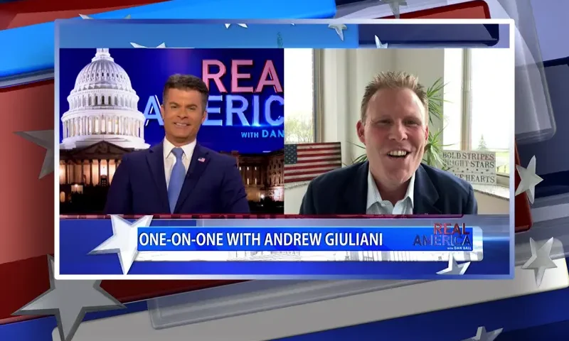 Video still from Real America on One America News Network showing a split screen of the host on the left side, and on the right side is the guest, Andrew Giuliani.