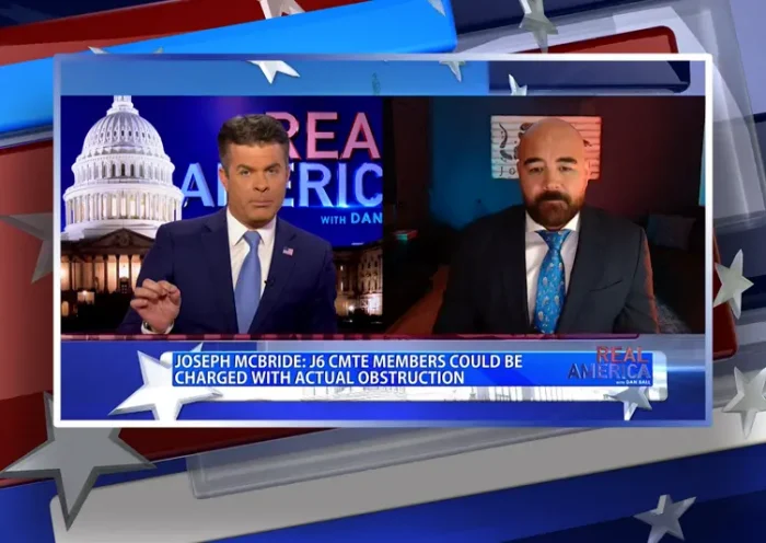 Video still from Real America on One America News Network showing a split screen of the host on the left side, and on the right side is the guest, Joseph McBride.