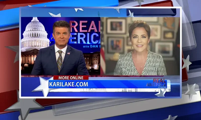 Video still from Real America on One America News Network showing a split screen of the host on the left side, and on the right side is the guest, Kari Lake.