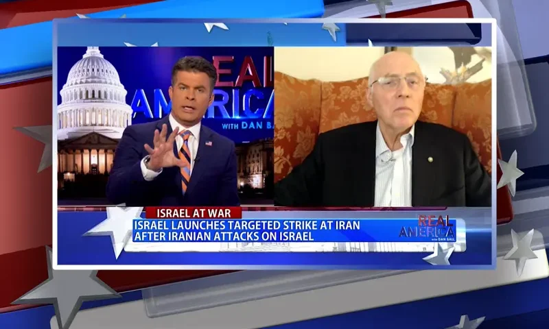 Video still from Real America on One America News Network showing a split screen of the host on the left side, and on the right side is the guest, Lt. Col. Robert Maginnis.
