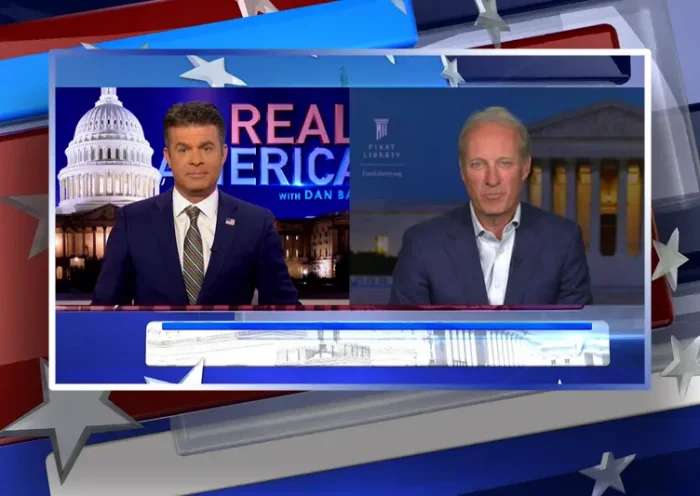Video still from Real America on One America News Network showing a split screen of the host on the left side, and on the right side is the guest, Kelly Shackelford.