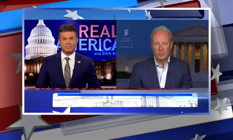 Video still from Real America on One America News Network showing a split screen of the host on the left side, and on the right side is the guest, Kelly Shackelford.