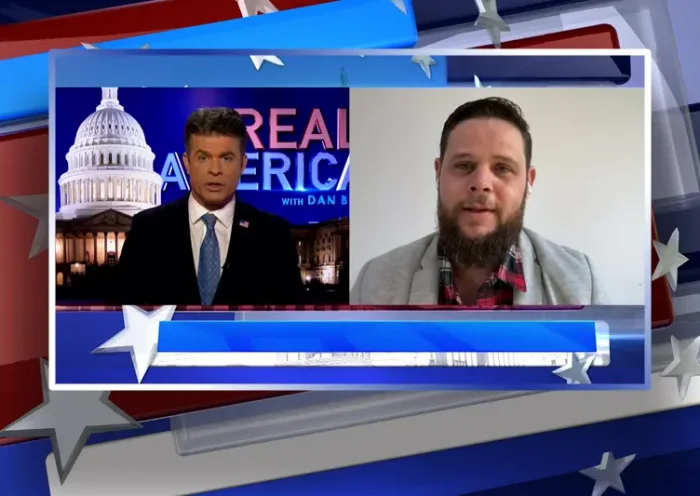 Video still from Real America on One America News Network showing a split screen of the host on the left side, and on the right side is the guest, Ricardo Martins.