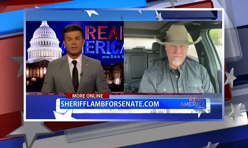 Video still from Real America on One America News Network showing a split screen of the host on the left side, and on the right side is the guest, Sheriff Mark Lamb.