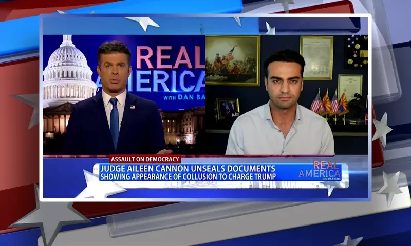 Video still from Real America on One America News Network showing a split screen of the host on the left side, and on the right side is the guest, Abe Hamadeh.