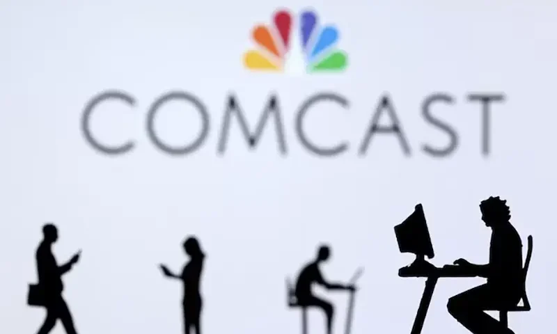 Small toy figures with laptops and smartphones are seen in front of displayed Comcast logo, in this illustration taken December 5, 2021. REUTERS/Dado Ruvic/Illustration/File Photo