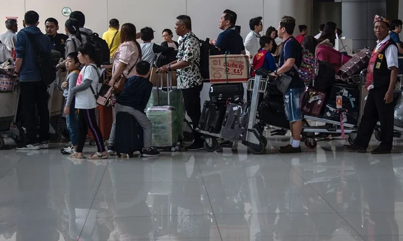 Passengers queue at an immigration desk as they arrive at the Juanda airport in Sidoarjo on the outskirts of Surabaya on January 22, 2020. - A new virus that has killed nine people, infected hundreds and already reached the United States could mutate and spread, China warned January 21, as authorities scrambled to contain the disease during the Lunar New Year travel season. (Photo by Juni Kriswanto / AFP) (Photo by JUNI KRISWANTO/AFP via Getty Images)