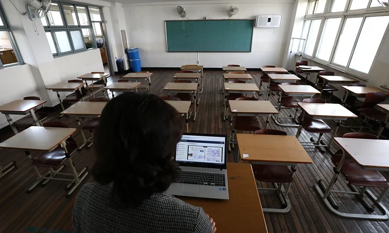 Schools Resume In South Korea Amid The Coronavirus Outbreak SEOUL, SOUTH KOREA - APRIL 09: A teacher wears a mask as she gives a lesson on the first day of online class in an empty classroom as South Koreans take measures to protect themselves against the spread of coronavirus (COVID-19) at Seoul Girls High School on April 09, 2020 in Seoul, South Korea. South Korea started the new school year in stages from today, beginning with online classes for middle and high school senior students. South Korea has called for expanded public participation in social distancing, as the country witnesses a wave of community spread and imported infections leading to a resurgence in new cases of COVID-19. According to the Korea Center for Disease Control and Prevention, 39 new cases were reported. The total number of infections in the nation tallies at 10,423. (Photo by Chung Sung-Jun/Getty Images)