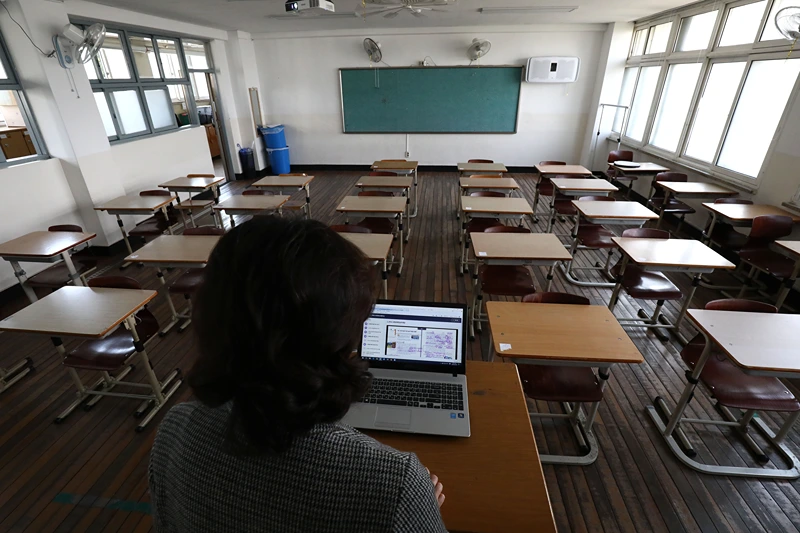 Schools Resume In South Korea Amid The Coronavirus Outbreak
SEOUL, SOUTH KOREA - APRIL 09: A teacher wears a mask as she gives a lesson on the first day of online class in an empty classroom as South Koreans take measures to protect themselves against the spread of coronavirus (COVID-19) at Seoul Girls High School on April 09, 2020 in Seoul, South Korea. South Korea started the new school year in stages from today, beginning with online classes for middle and high school senior students. South Korea has called for expanded public participation in social distancing, as the country witnesses a wave of community spread and imported infections leading to a resurgence in new cases of COVID-19. According to the Korea Center for Disease Control and Prevention, 39 new cases were reported. The total number of infections in the nation tallies at 10,423. (Photo by Chung Sung-Jun/Getty Images)