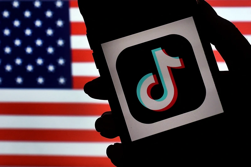 US-IT-CHINA-POLITICS-TIKTOK
In this photo illustration, the social media application logo, TikTok is displayed on the screen of an iPhone on an American flag background on August 3, 2020 in Arlington, Virginia. - The US Senate voted on August 6, 2020, to bar TikTok from being downloaded onto US government employees' telephones, intensifying US scrutiny of the popular Chinese-owned video app. The bill passed by the Republican controlled Senate now goes to the House of Representatives, led by Democrats. (Photo by Olivier DOULIERY / AFP) (Photo by OLIVIER DOULIERY/AFP via Getty Images)