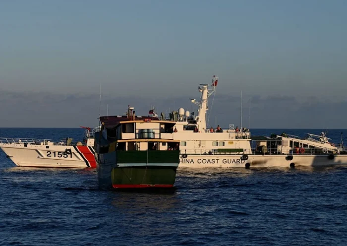 This photo taken on March 5, 2024 shows a China Coast Guard vessel (back) sailing near the Philippine military chartered Unaizah May 4 (front) during its supply mission to Second Thomas Shoal in the disputed South China Sea. The Philippines said on March 5 that China Coast Guard vessels caused two collisions with Philippine boats and water cannoned one of them, leaving four crew injured during a resupply mission in the South China Sea. (Photo by JAM STA ROSA / AFP) (Photo by JAM STA ROSA/AFP via Getty Images)